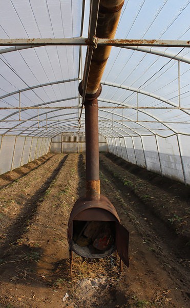 Как организовать отопление теплицы дровами?